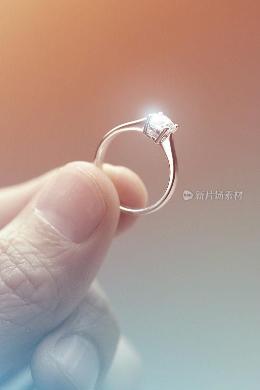 手握一枚钻石订婚戒指