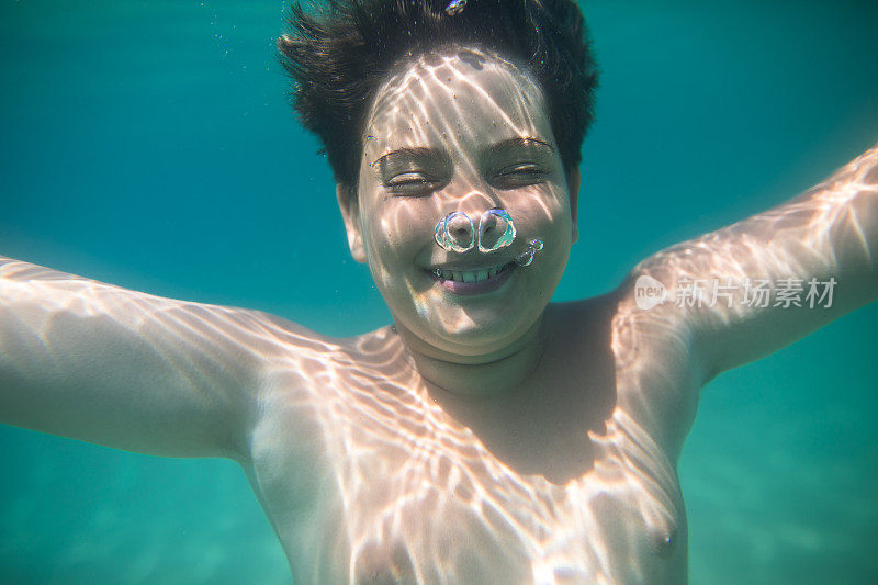 一个十几岁的男孩在海水里潜水