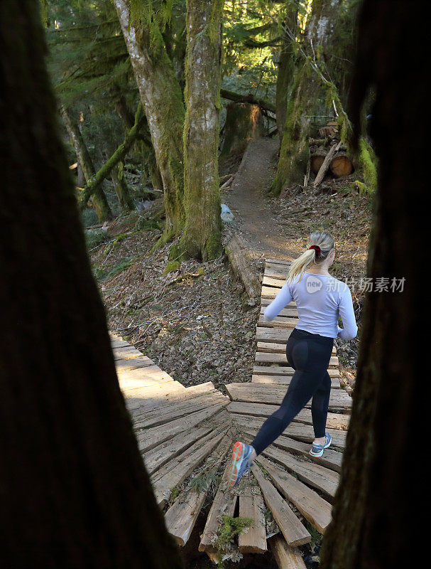 女性跑步者在木板人行道上跑步