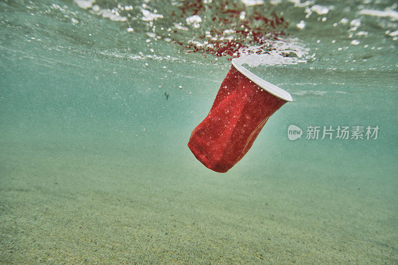 环境问题，红用一次性塑料杯在海里。