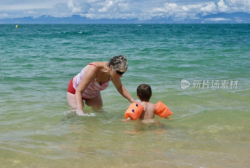 奶奶和孙子在夏天的海滩上