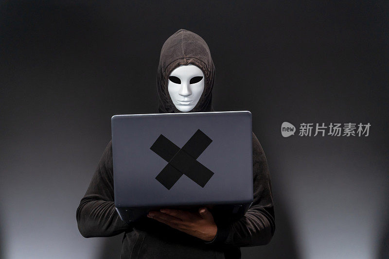 带面具的电脑黑客用笔记本电脑窃取信息