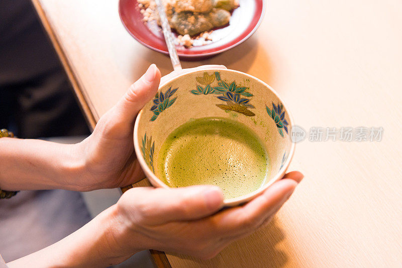 餐馆里拿着日本绿茶抹茶的女人