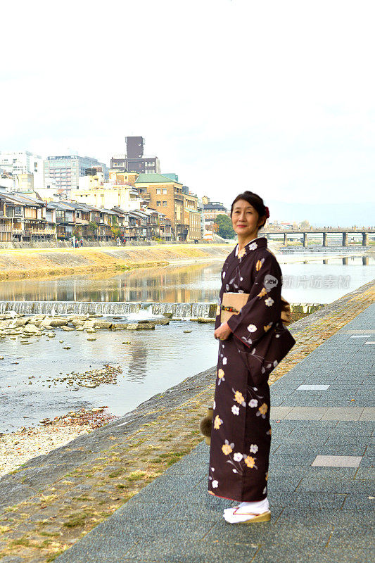 穿着和服的日本妇女沿着京都的加茂河行走