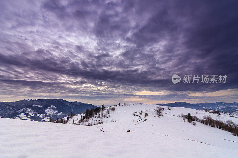 山峰上的雪被风吹走了。冬天的风景。天很冷，下着雪。