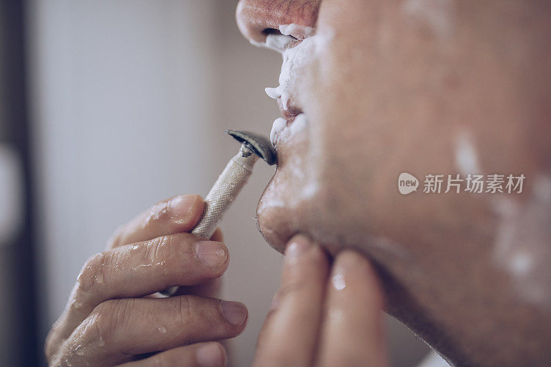 一个老人在刮胡子，准备上班