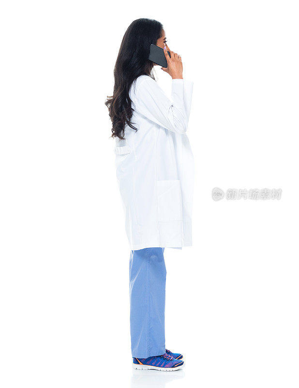 拉丁美洲和西班牙裔年轻女医生穿着实验服，使用手机