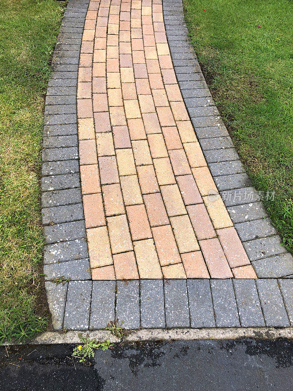 新红黄相间的砖砌小路，铺着灰色的石块，铺着花园小径
