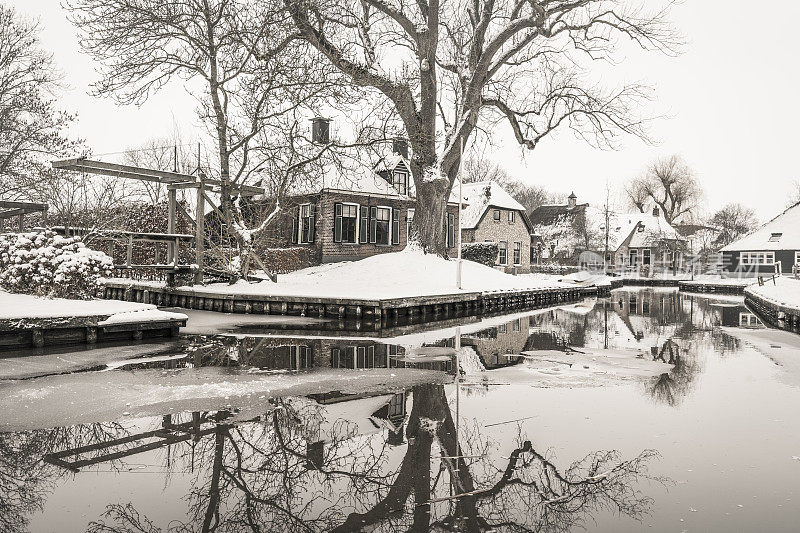 在一个寒冷但美丽而平静的冬天，Giethoorn村附近的Dwarsgracht有积雪的运河