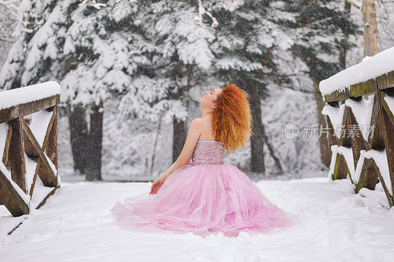 我的冬日童话，美丽的女孩穿着华丽的粉红色裙子享受着白雪覆盖的森林