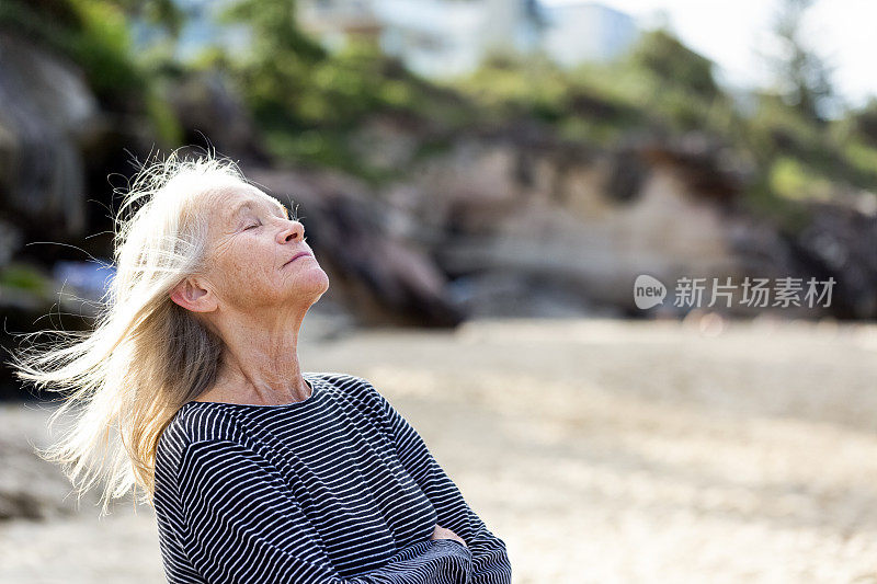 肖像现代迷人的妇女梦想在海滩上，背景与复制空间