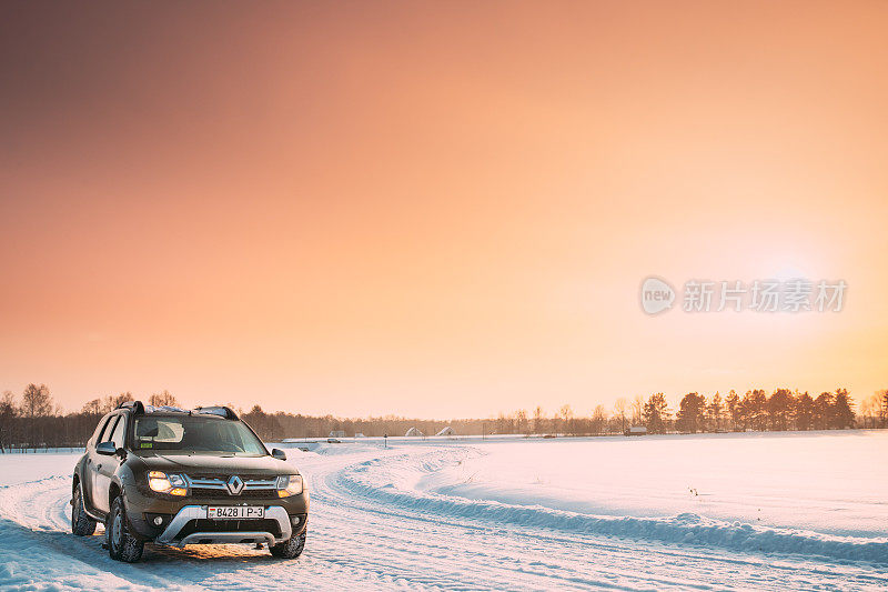 高美尔、白俄罗斯。汽车雷诺或达契亚除尘器越野车停在冬季雪原乡村景观。由法国制造商雷诺和罗马尼亚子公司达契亚联合生产的除尘器