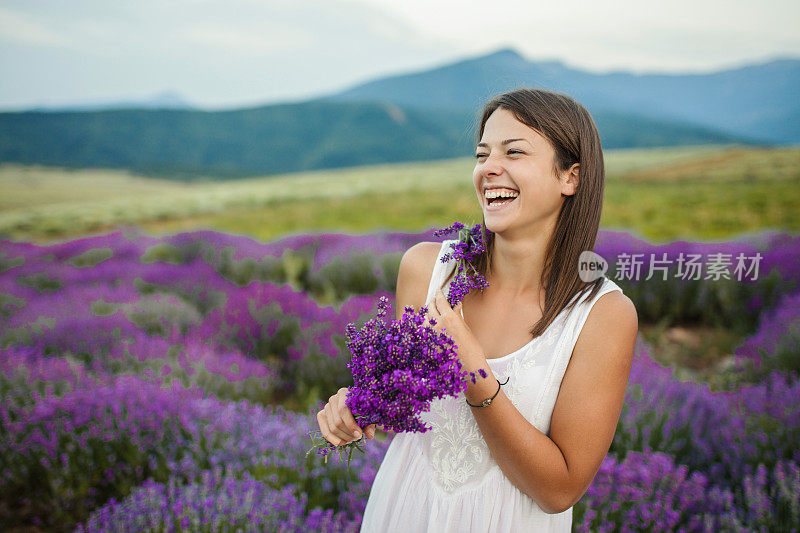 美丽的年轻女子在薰衣草地里享受