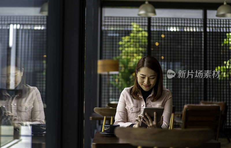 亚洲商业女性努力工作在她的ipad在共同工作办公室。