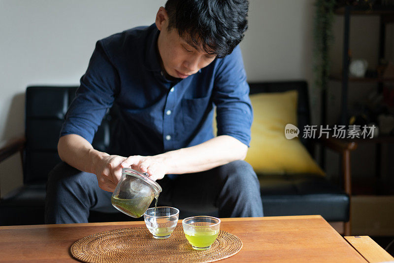 一个男人在自己家的客厅里泡日本茶