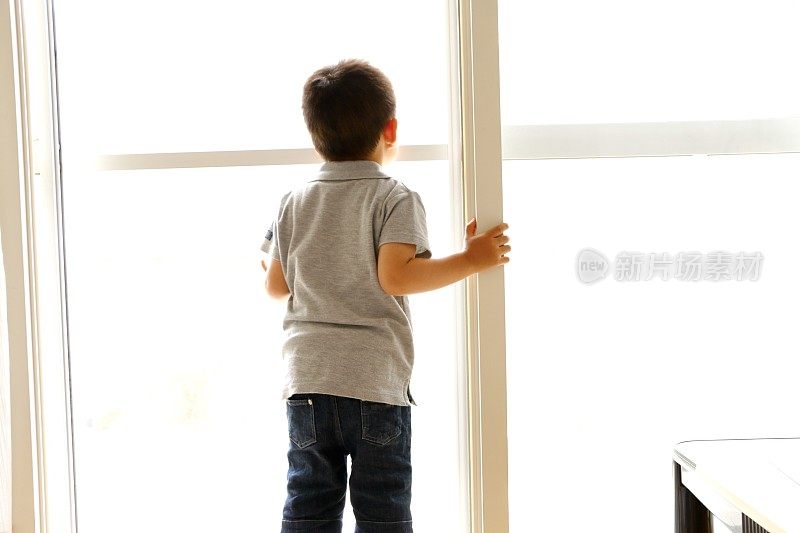小男孩从窗户往外看