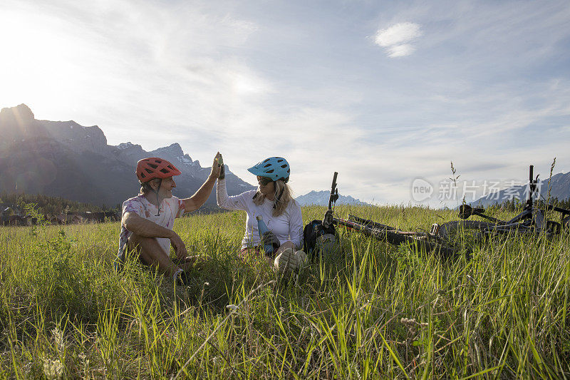一对夫妇骑着山地电动自行车在草地上放松
