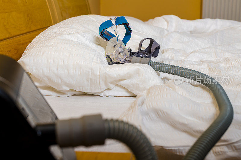 睡眠呼吸暂停面罩和软管的CPAP或APAP设备在枕头上