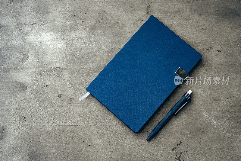 深灰色背景上的男人的日记和钢笔