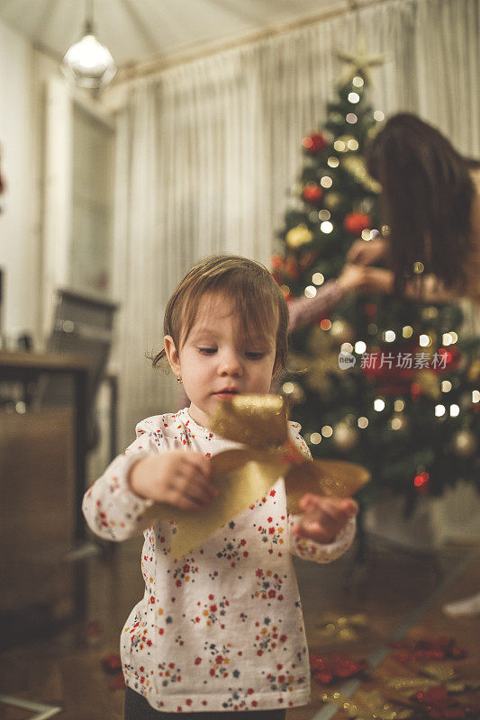 小女孩在玩闪闪发光的圣诞装饰品