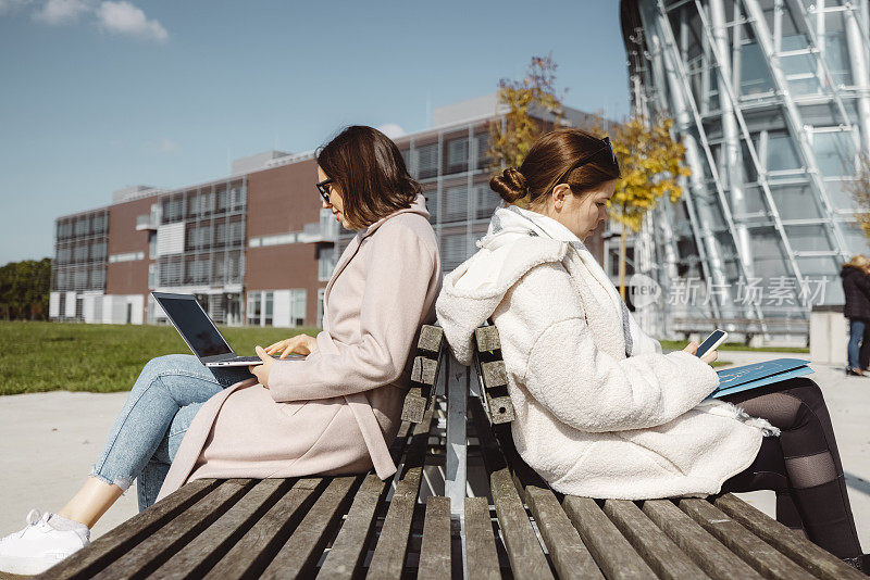 两个年轻女子，大学生，一起在外面学习