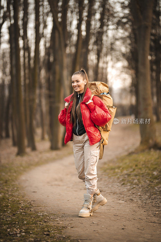 成功的女人徒步登山在日出的山顶-年轻的女人背包上升到山顶。发现旅游目的地