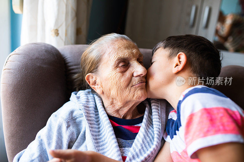 一位老妇人和她的曾孙接吻