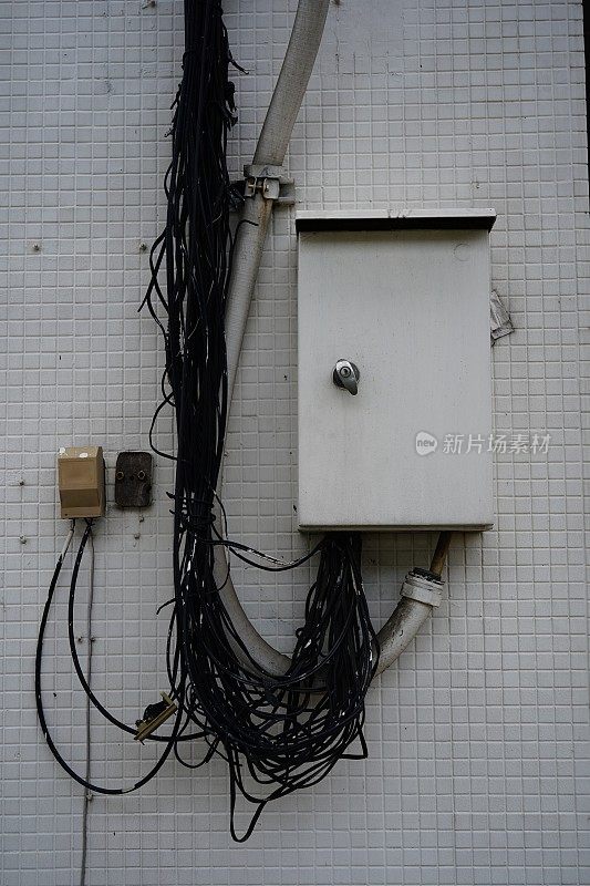 外面墙上挂着电线的电面板