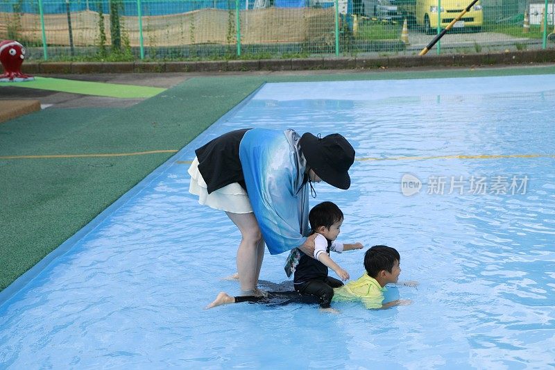 母亲和孩子在游泳池里玩耍