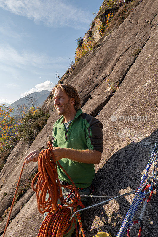 男登山者在山石板上整理绳索