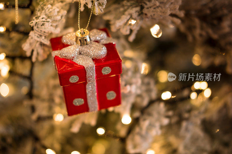 特写圣诞树装饰小红色礼物与银弓。