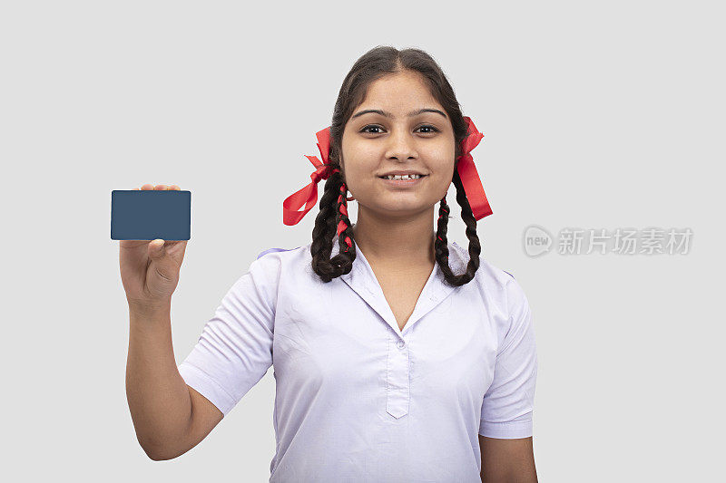 年轻的上学女孩展示信用卡库存照片