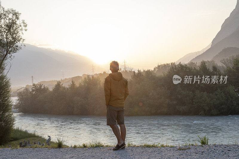 日出时，一名男子在河边休息