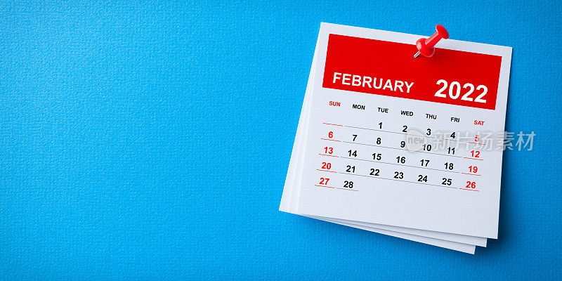 白色便利贴与2022年2月日历和红色图钉在蓝色背景