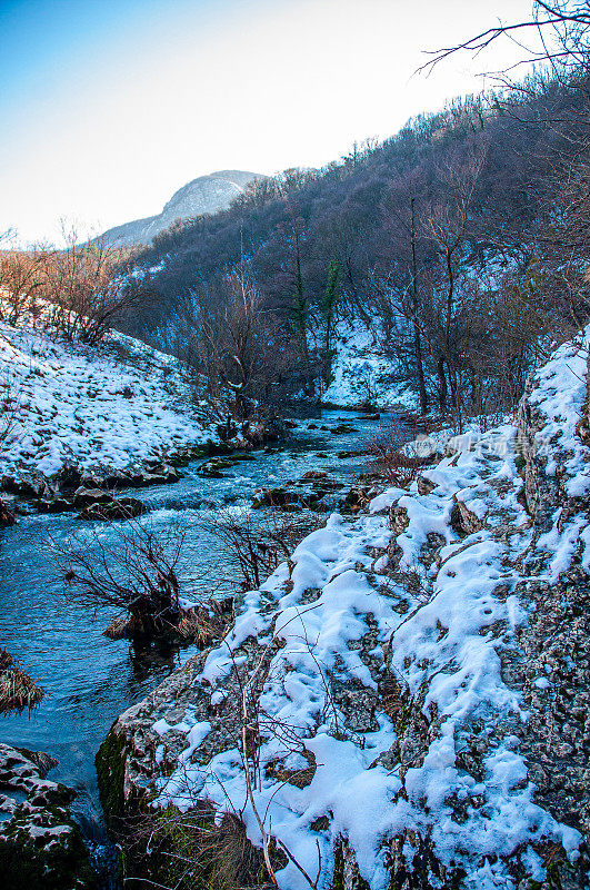 冬季山地景观，河流积雪和树木，最喜欢野餐的地方