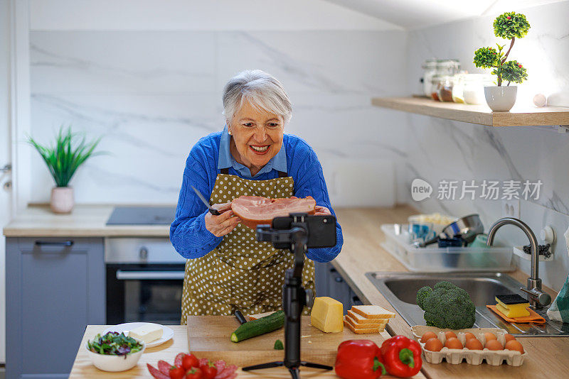 妇女准备食物配方，同时在线流与移动智能手机摄像头为网络厨房大师班频道