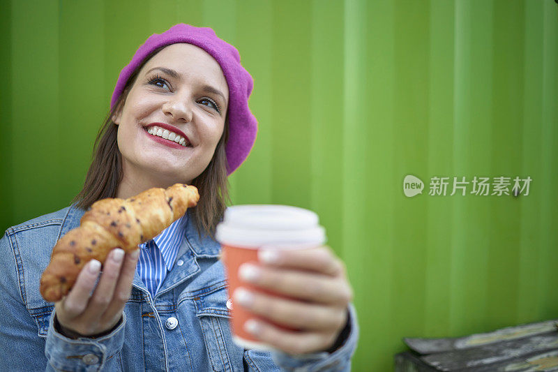 女人咬牛角面包户外酒吧早餐