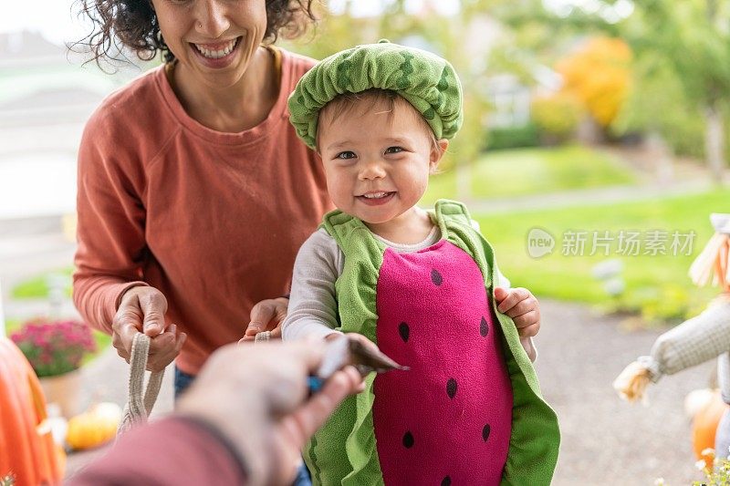 可爱的小女孩在万圣节玩“不给糖就捣蛋”的游戏