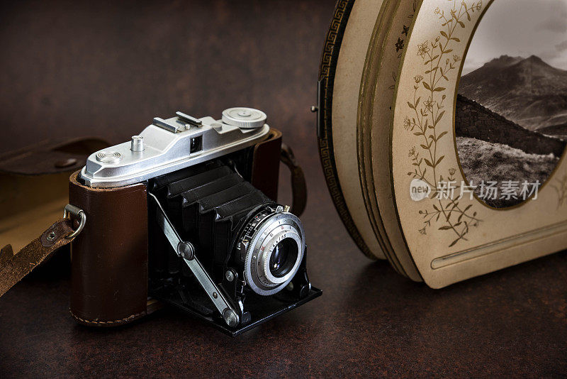 古董折叠风箱相机皮革表带和皮革古董相册-库存照片