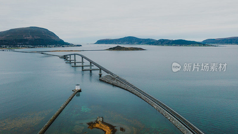 航拍汽车行驶在风景优美的海桥上，在挪威岛上看到灯塔