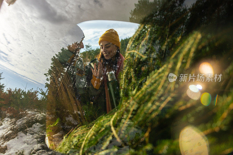 车窗反射着一对年轻的白人夫妇，还有一棵圣诞树