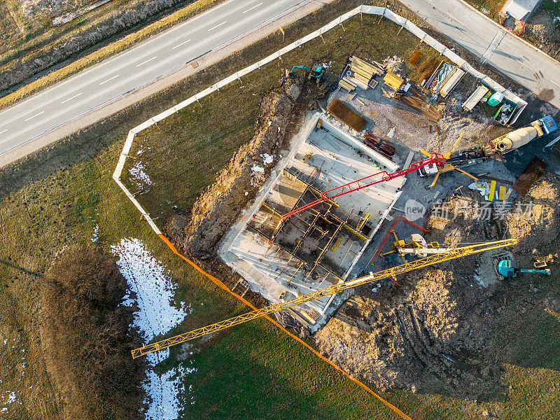 混凝土泵车将混合物运送到正在施工的建筑物，俯视图