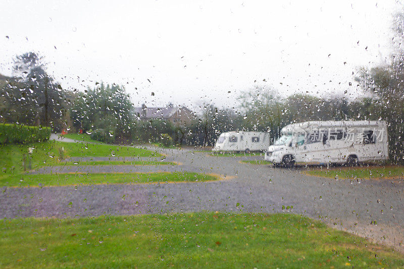 雨天和假日——在寒冷潮湿的日子里，从大篷车里往外看，俯瞰大篷车和露营车，典型的英国假日假期天气，下雨
