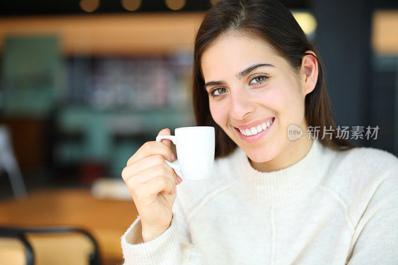 酒吧里拿着咖啡杯微笑的快乐女人