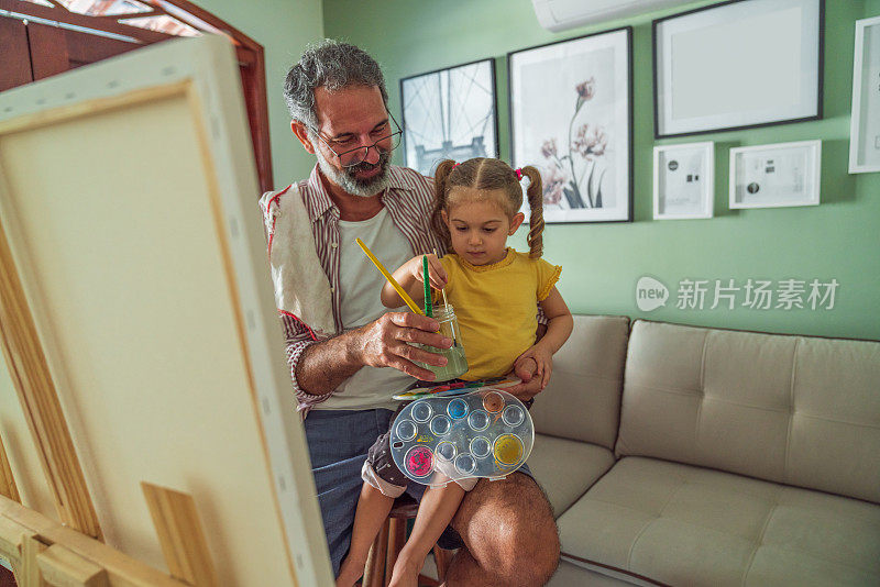爷爷和孙女在客厅里画画，玩得很开心。