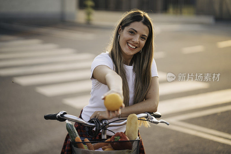 买完杂货后骑自行车的漂亮女孩