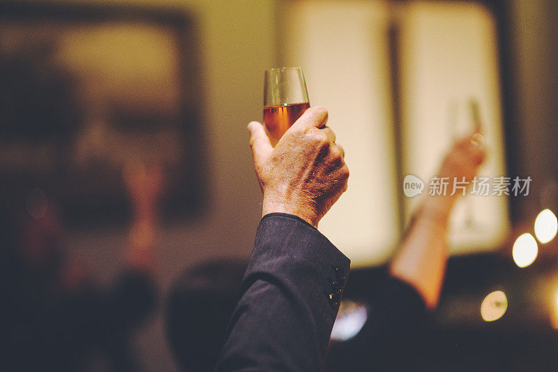 在晚上的活动中，男性手持香槟酒欢呼庆祝
