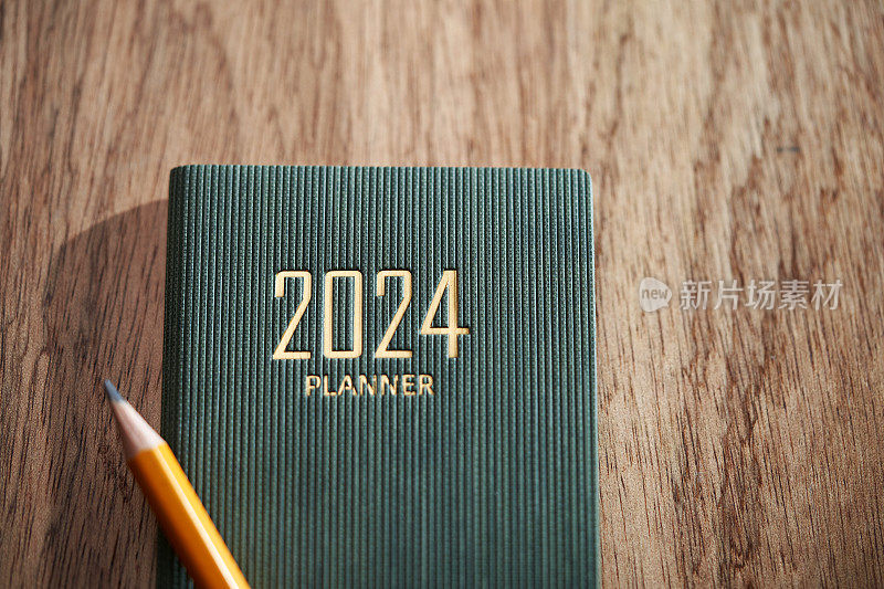 木制背景上的2024计划和黄色铅笔