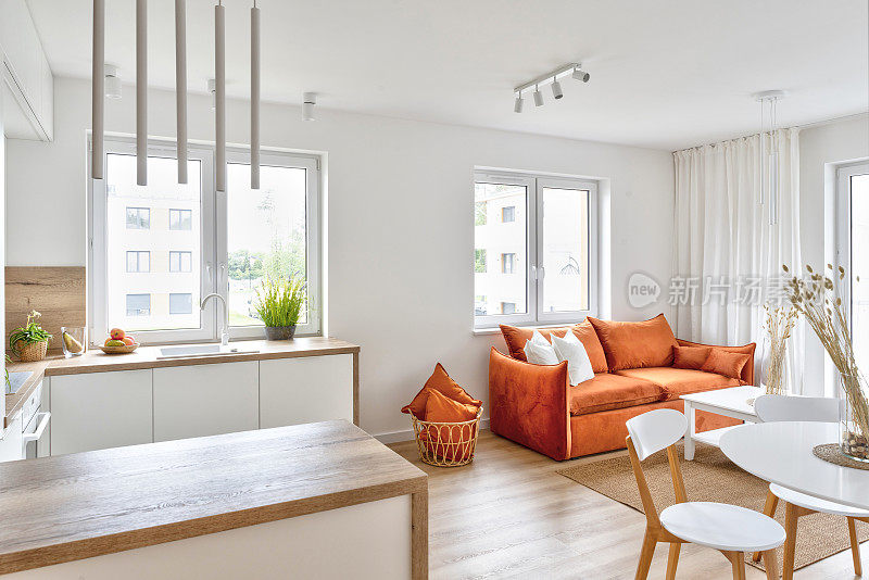 现代室内设计风格，厨房和带窗的客厅。配有时髦家具的新公寓。