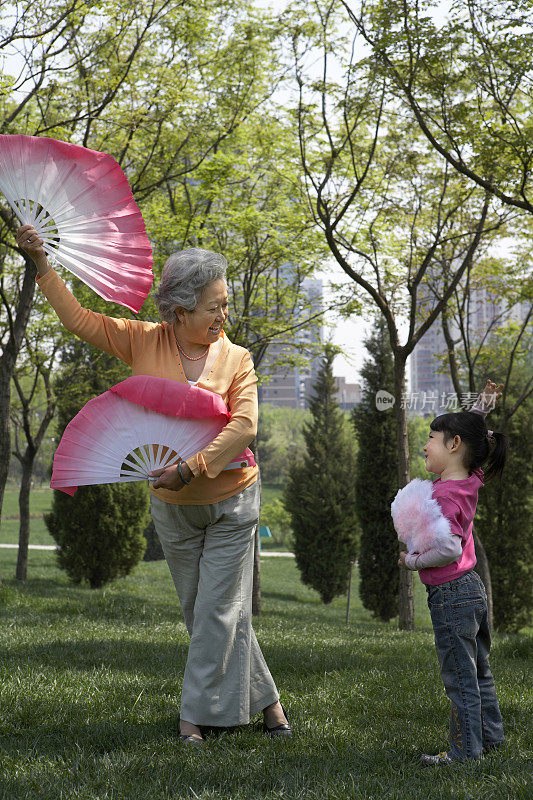老人和女孩在公园练习扇舞
